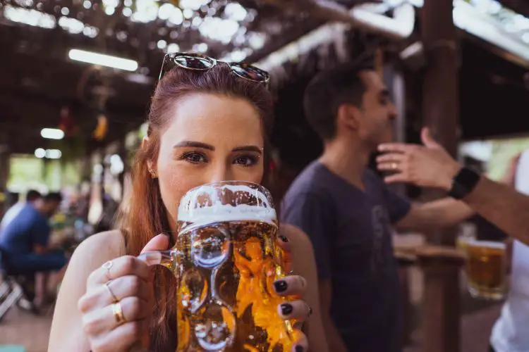 why put salt in beer - girl drinking beer from a giant mug