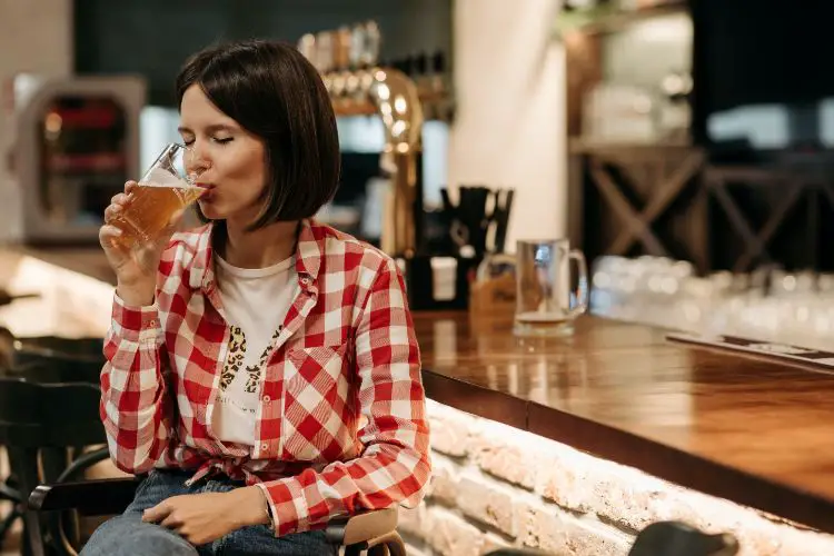 A Lady Enjoying Beer In A Restaurant.