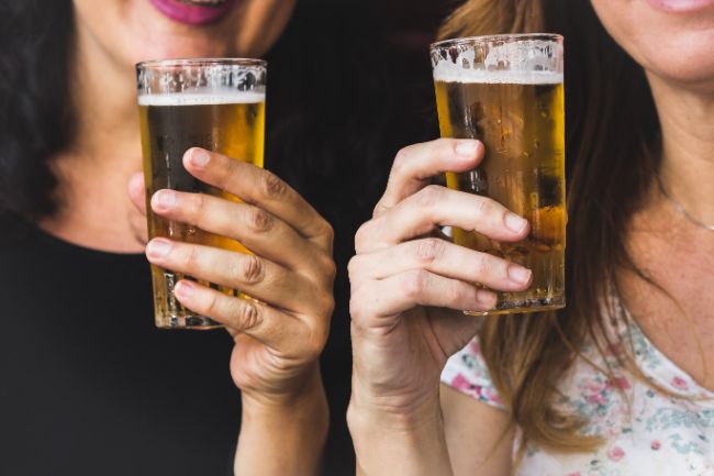 2 girls drinking wondering Why Does Draft Beer Taste Better