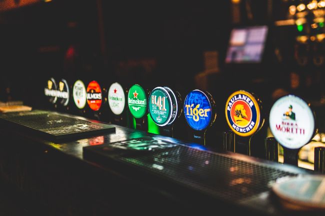 Different Draft Beer Brands In A Bar.