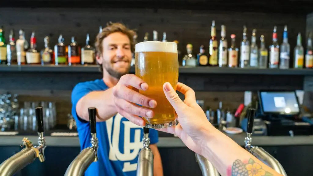 Serving A Customer A Glass Of Cold Brew.