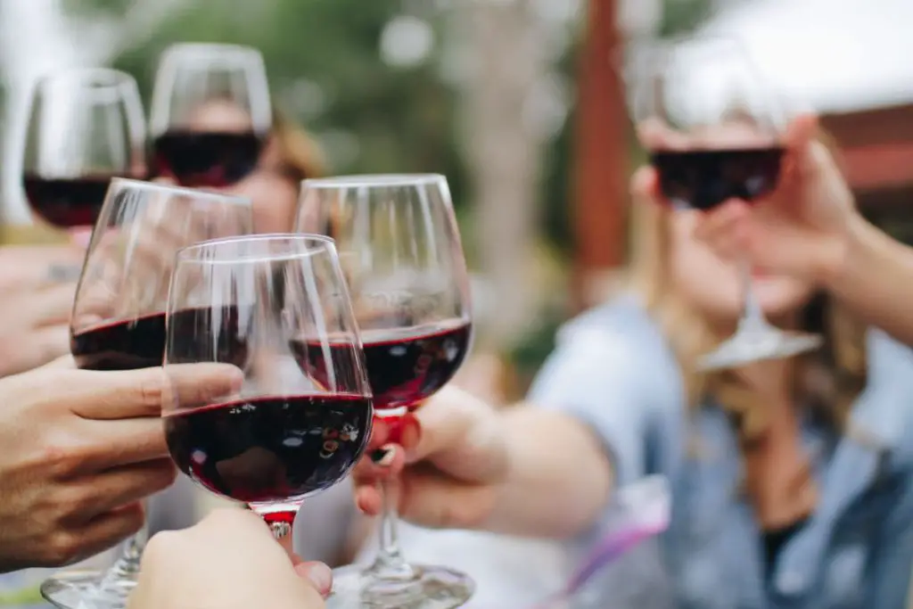 Clicking Red Wine Glasses Together To Enjoy The Flavor.