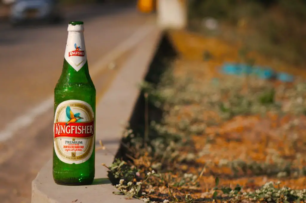 A Kingfisher Empty Bottle On A Ledge.