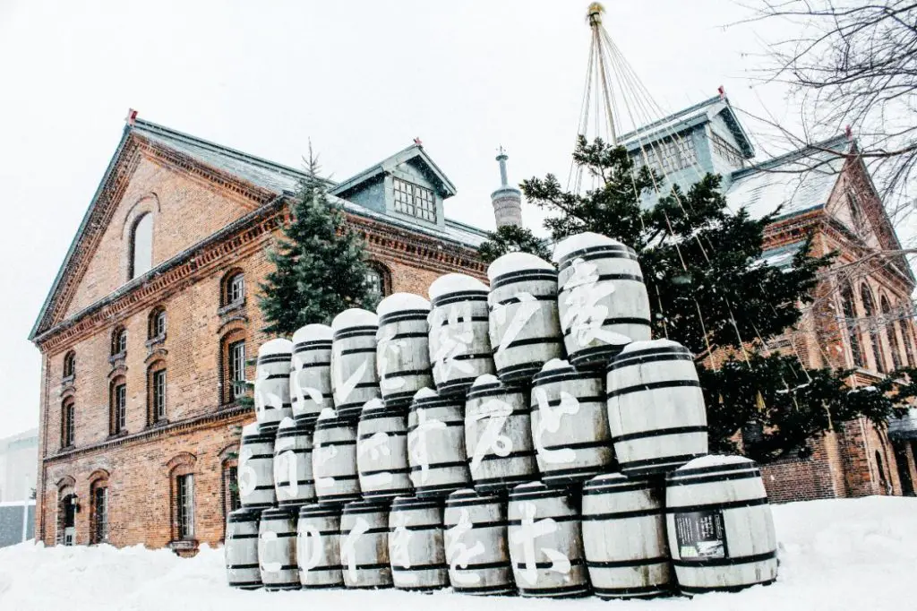 Beer Barrels In Front Of A Brick Building.